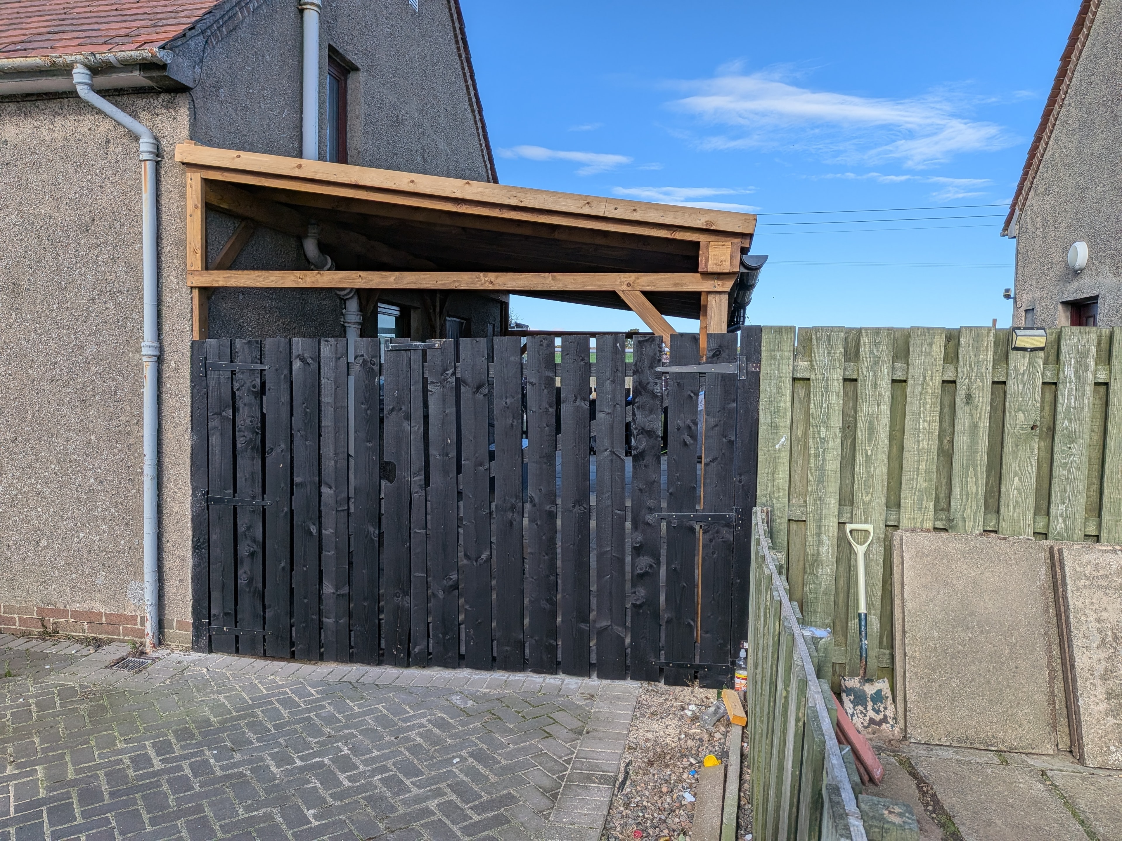 Timber-framed canopy with black painted fence