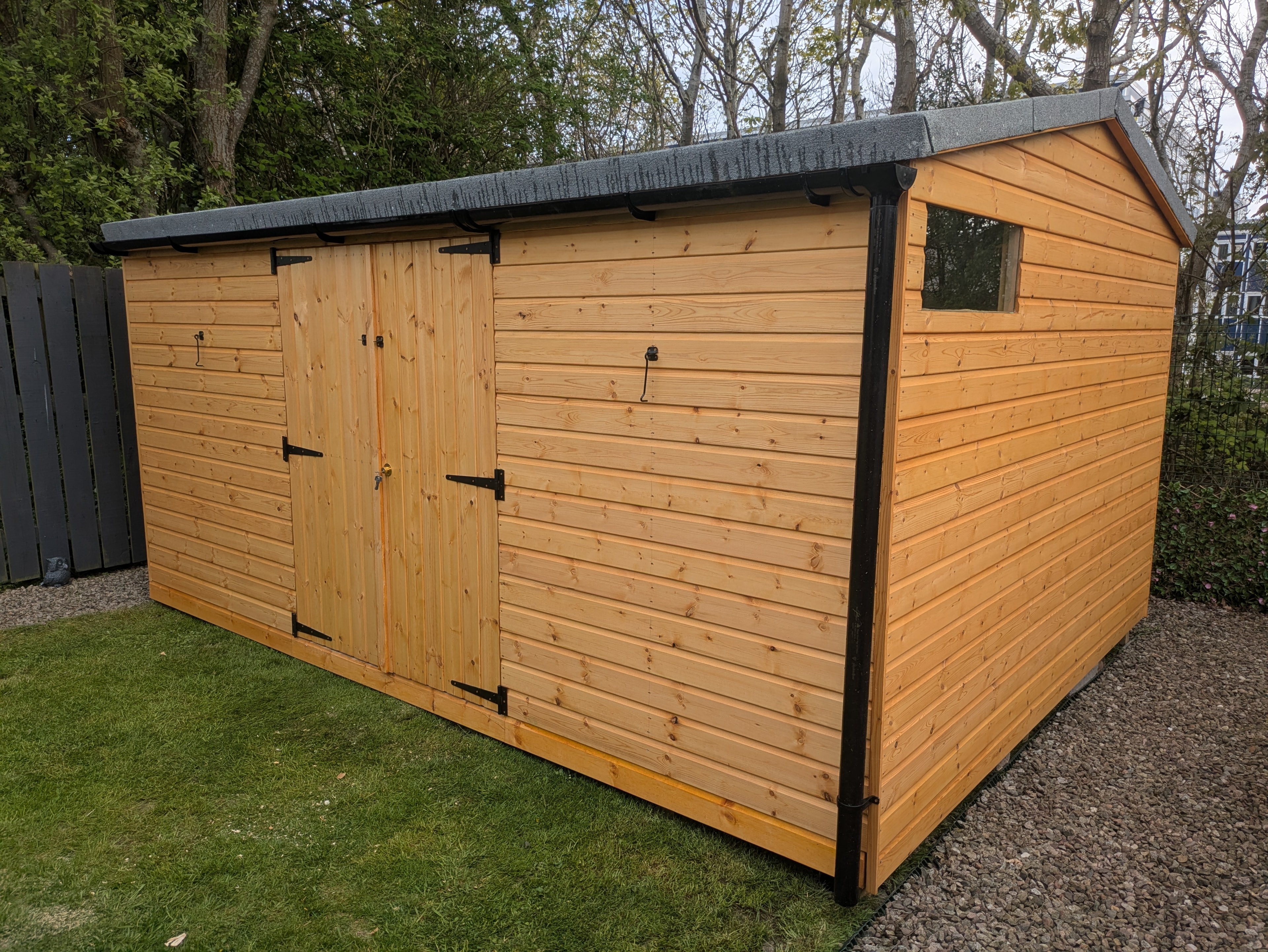 Natural timber workshop with double doors and black guttering