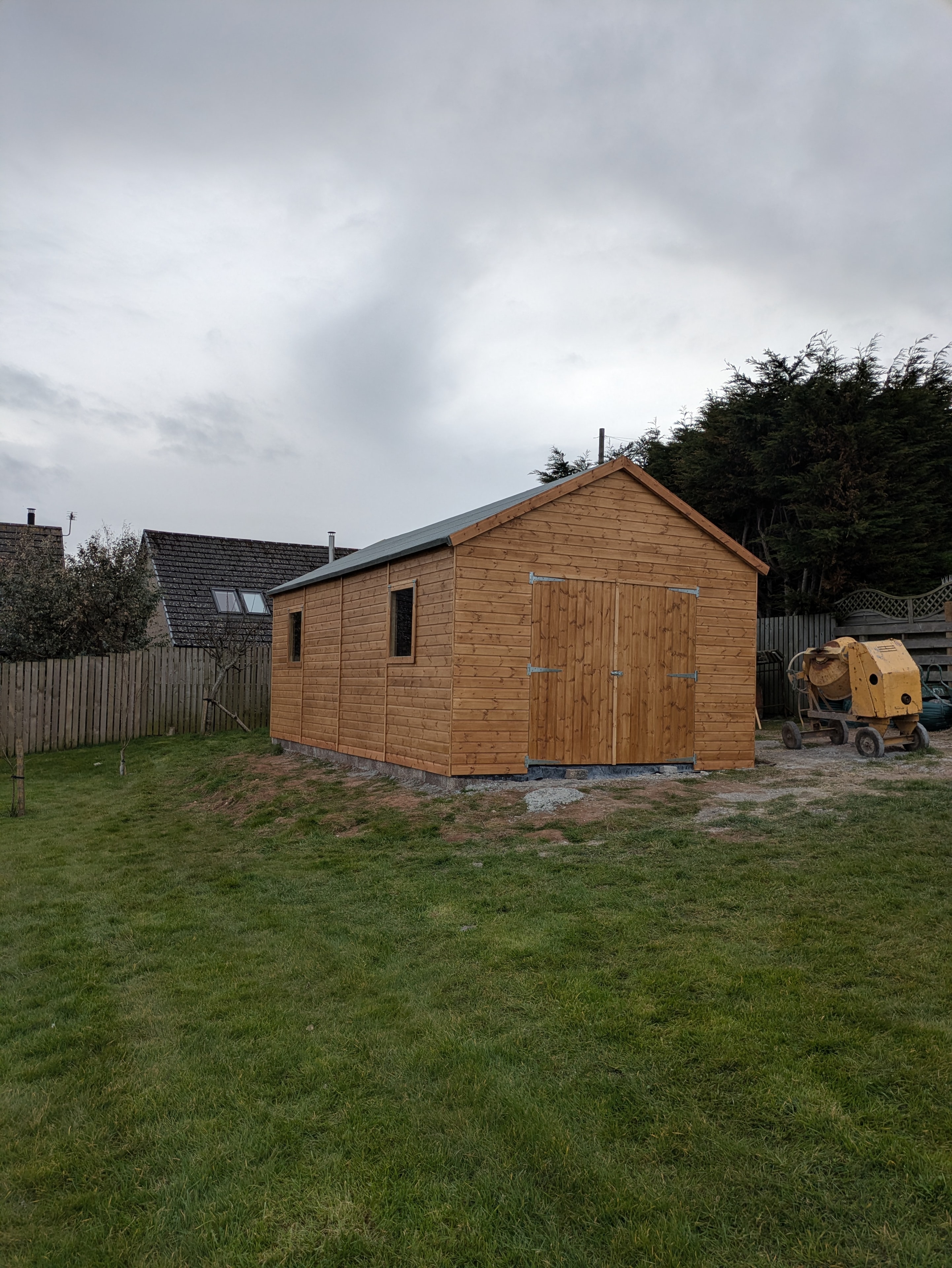 Large timber workshop with sliding doors in garden setting